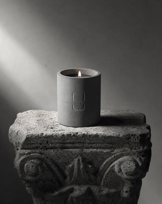 URU Candle Affa Noir — brutalist concrete candle vessel on a raw stone ledge, luxury minimalist design